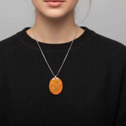 Collier pendentif résine orange pailleté lunes hexagones - Ovale chaleureux motifs cosmiques - Bijou artisanal unique fait main