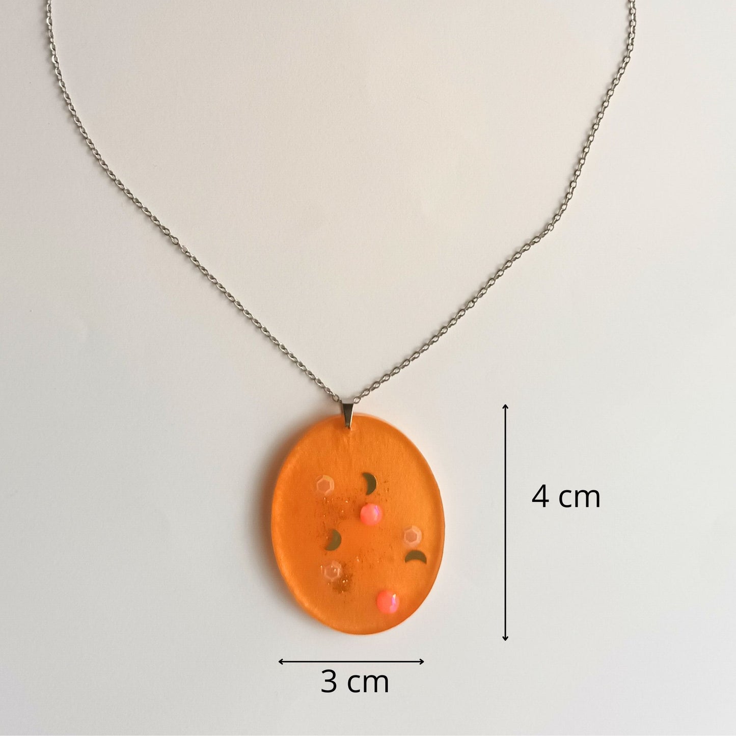 Collier pendentif résine orange pailleté lunes hexagones - Ovale chaleureux motifs cosmiques - Bijou artisanal unique fait main